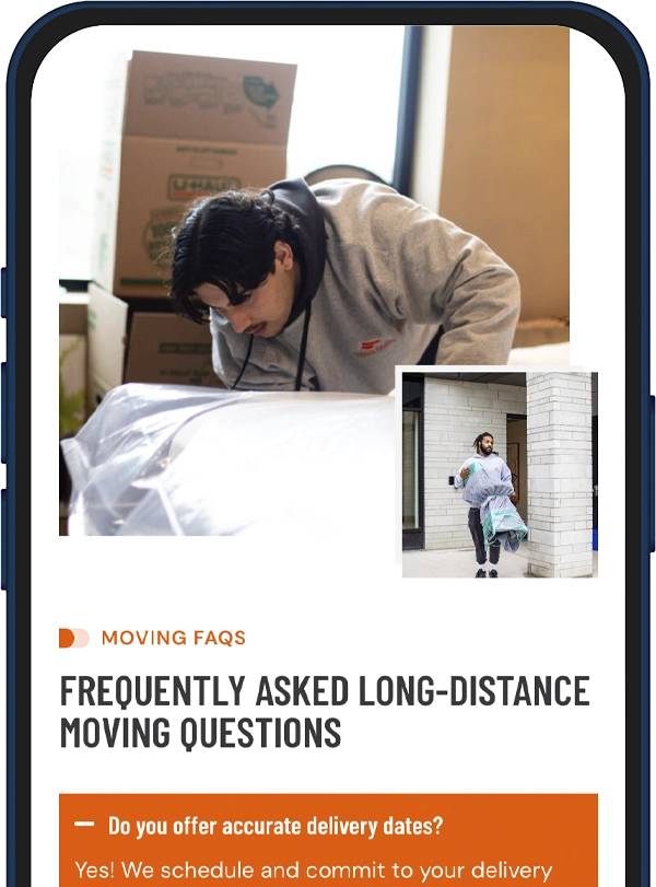 Mover leaning over a wrapped item while packing; cardboard boxes stacked behind, on a moving service article banner