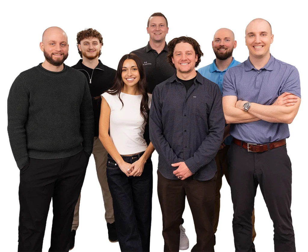 Group of seven coworkers posing together in casual clothes, smiling.